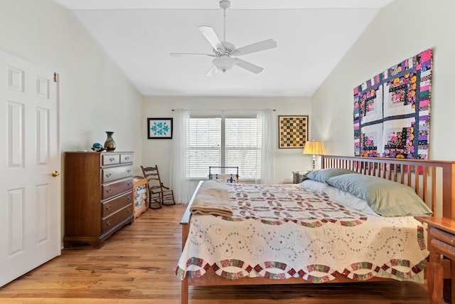 bedroom featuring lofted ceiling, light wood-type flooring, and a ceiling fan