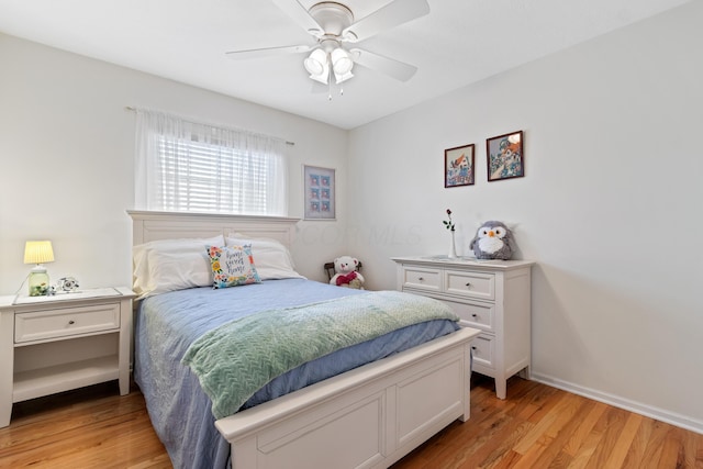 bedroom with light wood-style floors, baseboards, and a ceiling fan