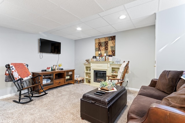 carpeted living room with recessed lighting, a glass covered fireplace, a paneled ceiling, and baseboards