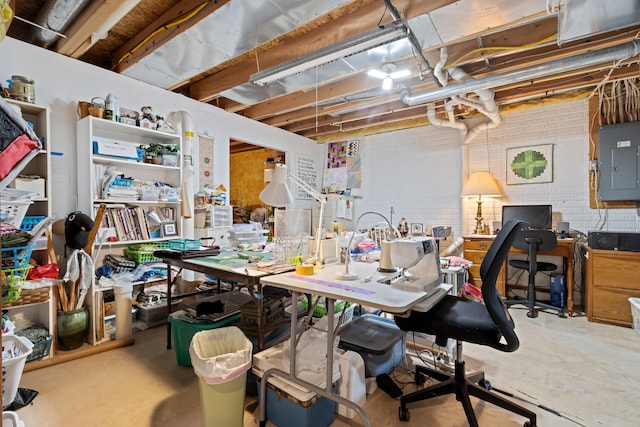 interior space with brick wall, a workshop area, and electric panel