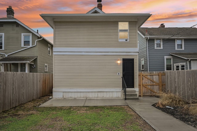 back of property with entry steps and fence