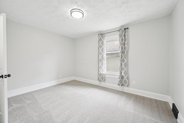 unfurnished room featuring carpet floors, baseboards, and a textured ceiling