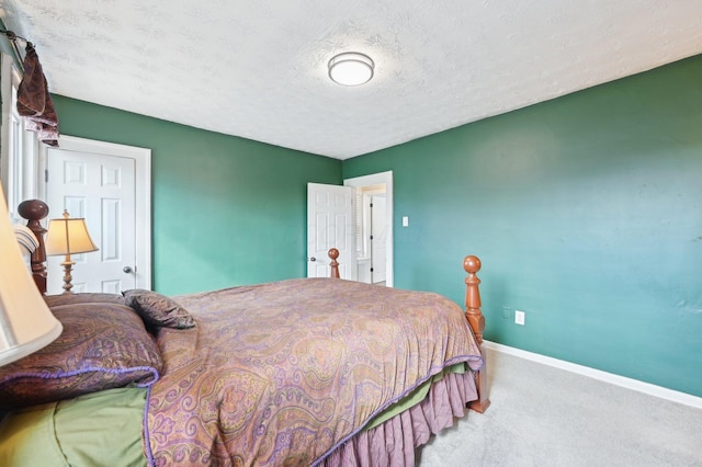 bedroom featuring a textured ceiling, carpet flooring, and baseboards