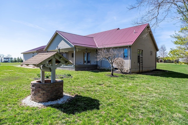 back of house featuring metal roof, a lawn, and a porch