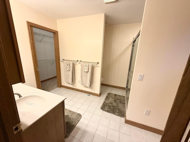 full bathroom with tile patterned floors, visible vents, a walk in closet, and a shower stall