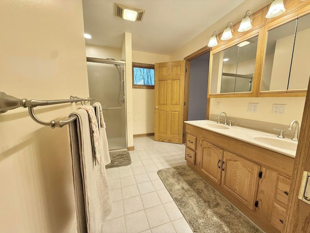 bathroom featuring a sink, visible vents, a shower stall, and tile patterned floors