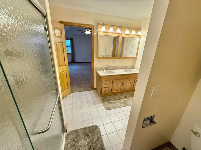 bathroom featuring a sink, a stall shower, a ceiling fan, and tile patterned floors