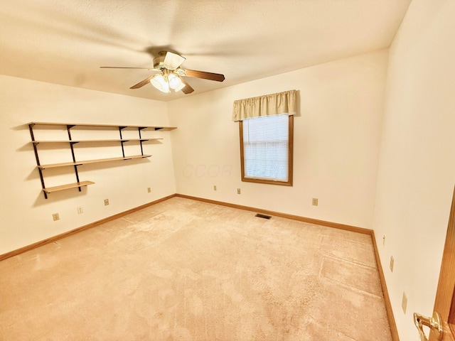unfurnished room with baseboards, light colored carpet, and ceiling fan