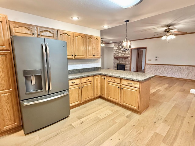 kitchen featuring a wainscoted wall, light wood-type flooring, ceiling fan, stainless steel fridge, and open floor plan