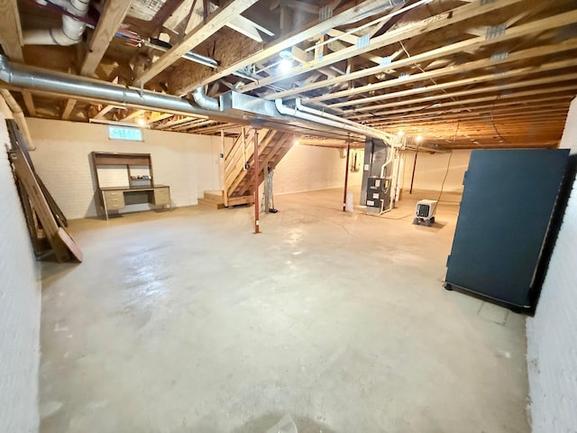 basement featuring stairway and heating unit