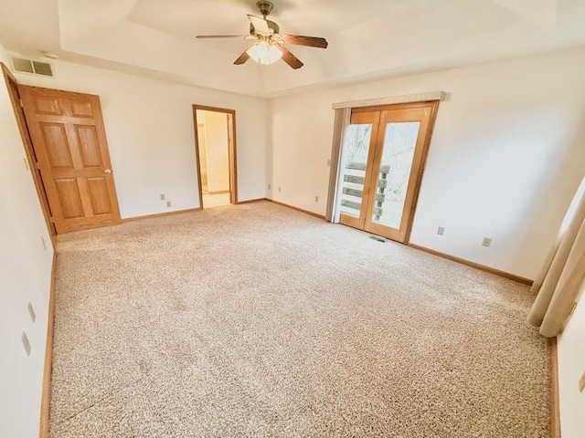 unfurnished bedroom featuring visible vents, a raised ceiling, baseboards, and access to outside