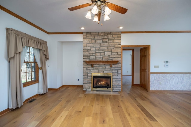 unfurnished living room featuring visible vents, ornamental molding, a stone fireplace, light wood finished floors, and ceiling fan