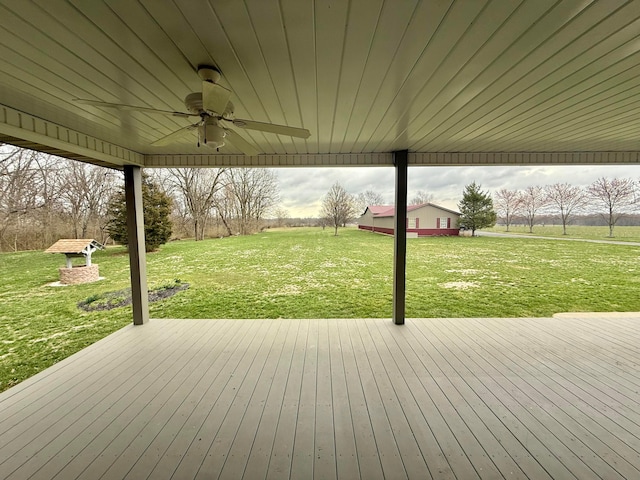 wooden deck featuring a yard and a ceiling fan