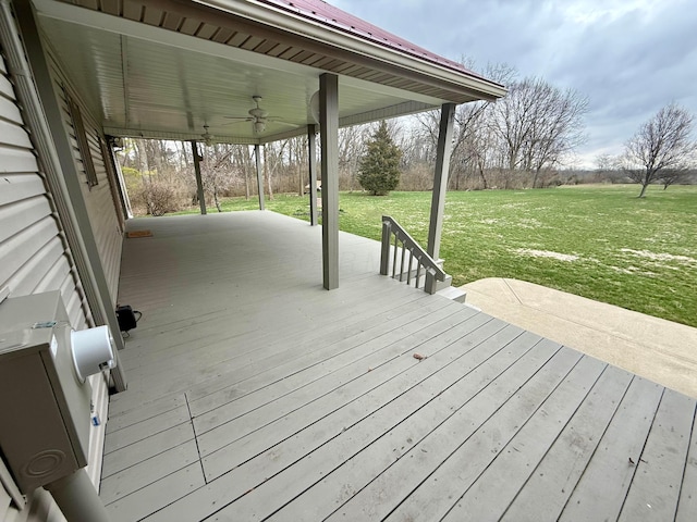 wooden deck featuring a ceiling fan and a yard