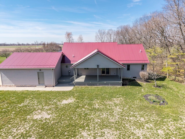 back of property featuring metal roof and a lawn