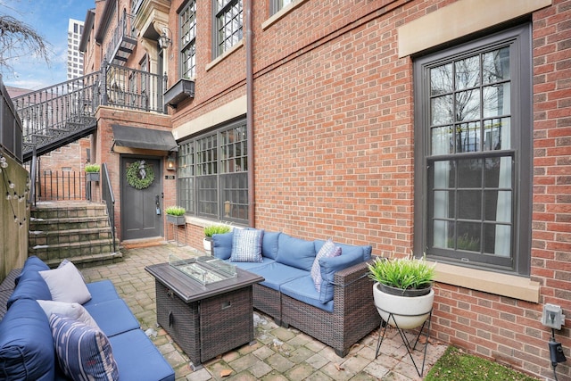 view of patio / terrace featuring stairway and an outdoor living space with a fire pit