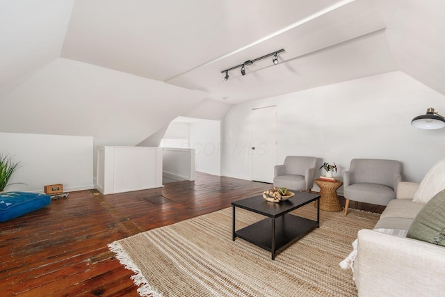 living room featuring dark wood-style flooring, rail lighting, vaulted ceiling, and baseboards