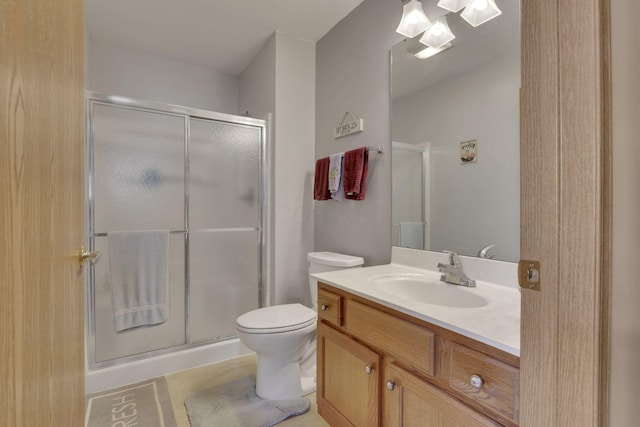 bathroom with a stall shower, vanity, and toilet