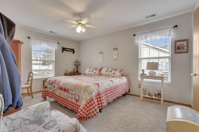 bedroom featuring visible vents, light carpet, and baseboards