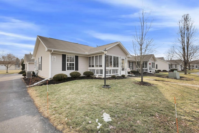 single story home with a garage, a front lawn, and central AC unit