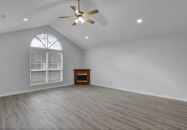 unfurnished living room with vaulted ceiling, ceiling fan, baseboards, and wood finished floors