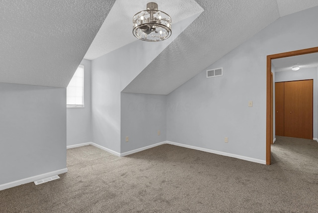 bonus room featuring baseboards, visible vents, a textured ceiling, and light colored carpet