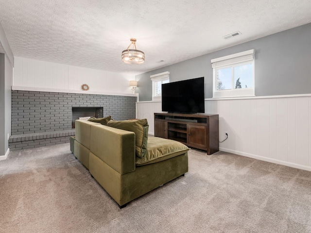 living area with carpet, visible vents, and a textured ceiling