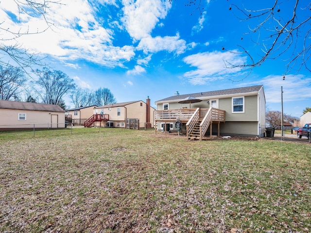 back of property featuring a deck, stairway, fence, and a lawn