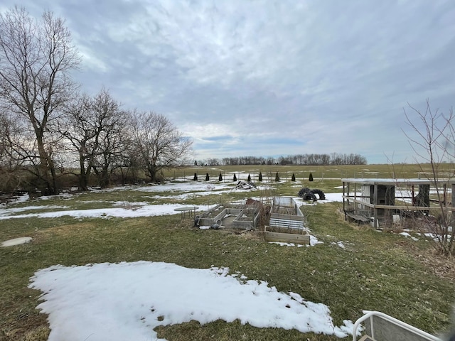 yard covered in snow featuring a rural view