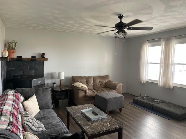 living room featuring ceiling fan, a textured ceiling, and wood finished floors