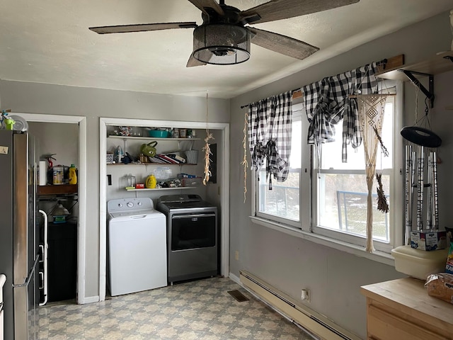 kitchen featuring a ceiling fan, freestanding refrigerator, light floors, a baseboard heating unit, and separate washer and dryer