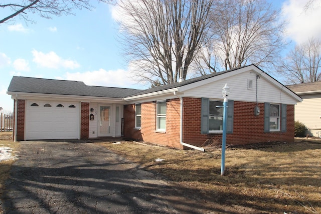 single story home featuring brick siding, driveway, and an attached garage