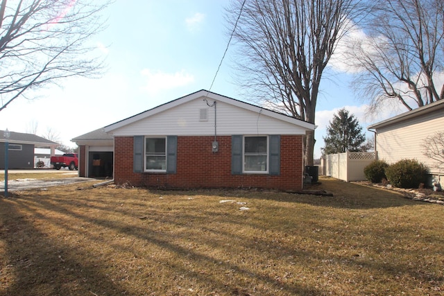 view of side of home with driveway, an attached garage, a yard, central AC, and brick siding