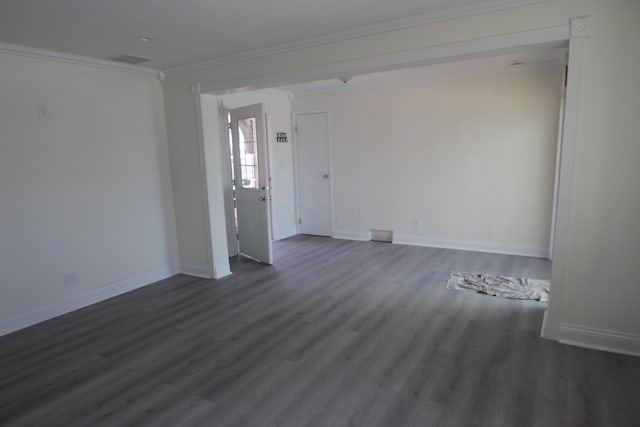 empty room with ornamental molding, dark wood-type flooring, and baseboards