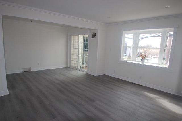 empty room with baseboards, dark wood-type flooring, and crown molding