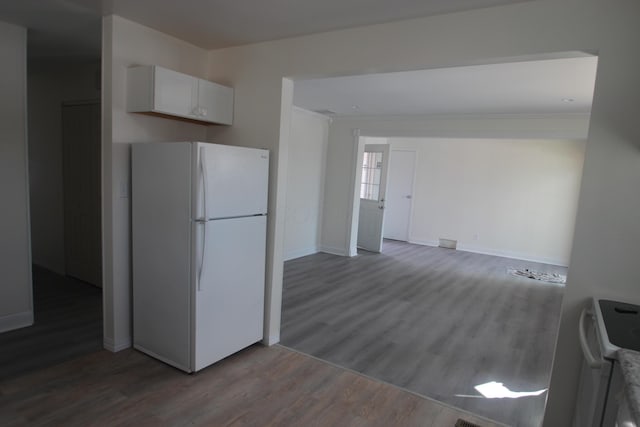 kitchen with wood finished floors, white cabinetry, baseboards, ornamental molding, and freestanding refrigerator