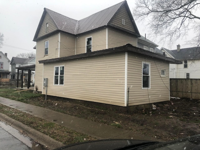 view of home's exterior featuring metal roof and fence