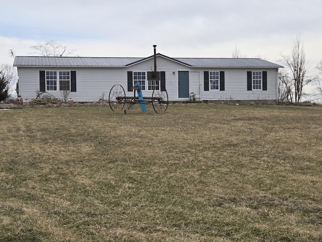 manufactured / mobile home featuring a front lawn and metal roof