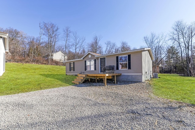 manufactured / mobile home featuring cooling unit, a deck, and a front lawn