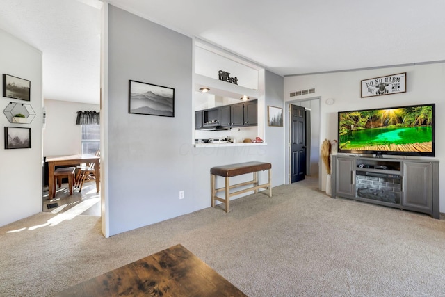 living room featuring lofted ceiling, visible vents, and light carpet