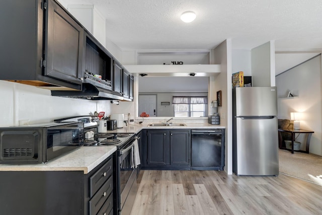 kitchen featuring a sink, stainless steel appliances, light wood-style floors, and light countertops