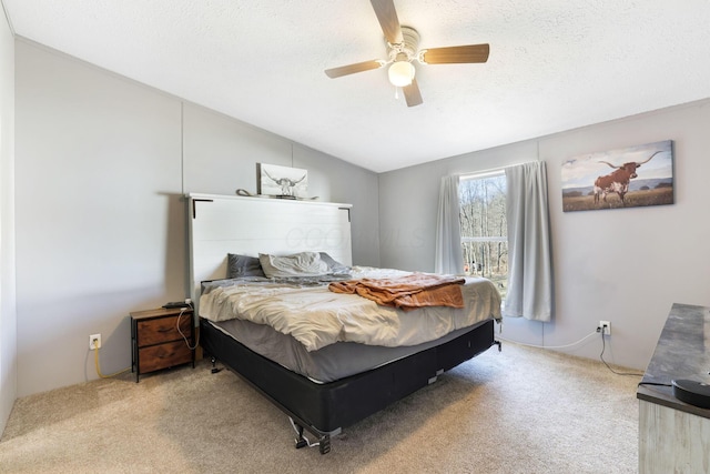 bedroom with ceiling fan, vaulted ceiling, carpet flooring, and a textured ceiling