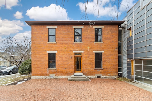 back of property featuring brick siding