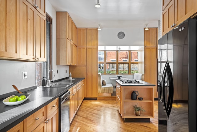 kitchen with dark countertops, light wood-type flooring, black appliances, open shelves, and a sink