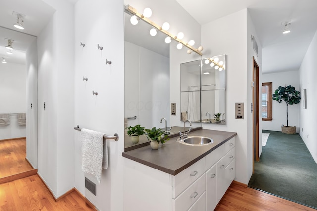 bathroom featuring visible vents, vanity, and wood finished floors