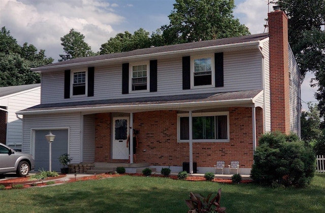 traditional home featuring a garage, brick siding, a chimney, and a front yard