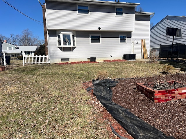 back of property featuring a lawn and fence