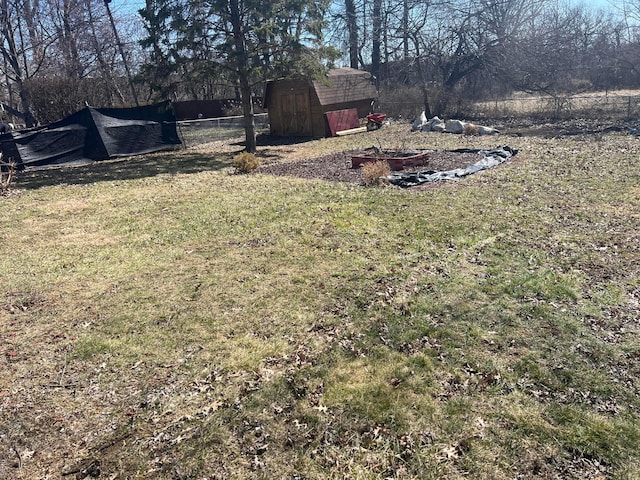 view of yard with a shed, fence, and an outbuilding