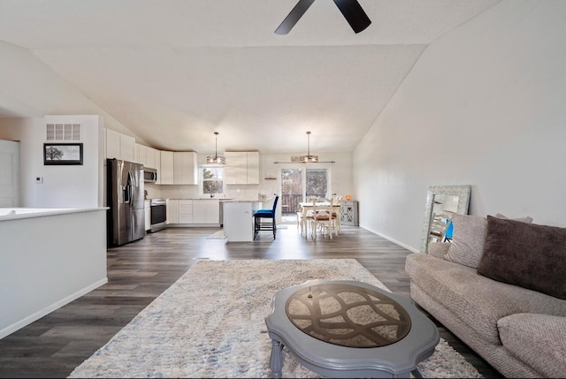 living area with a ceiling fan, lofted ceiling, dark wood-style flooring, and baseboards