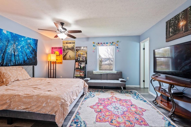 bedroom featuring a textured ceiling, wood finished floors, a ceiling fan, and baseboards